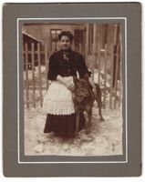 Fotografie Frau mit Hund vor Holzzaun