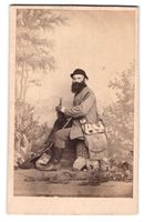 Fotografie Sitzender Jäger mit Gewehr u