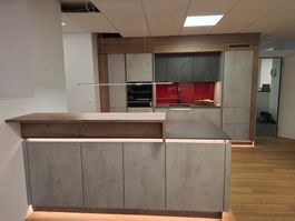 Moderne Küche in Betonoptik mit Holzelementen