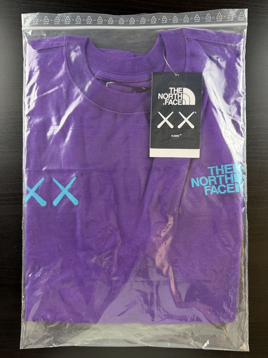 North Face T-shirt: Kaws x The North Face - Tee Purple – Nuovo e nell'imballaggio originale da Haag (Rheintal) venduto da BNMC.store