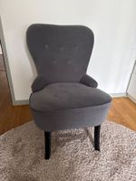 Grauer Polstersessel mit Armlehnen