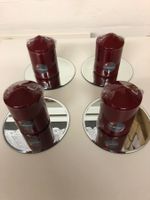 4 rote Zylinderkerzen auf Spiegelteller