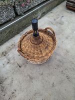 Grosse Glasballonflasche im Weidenkorb 