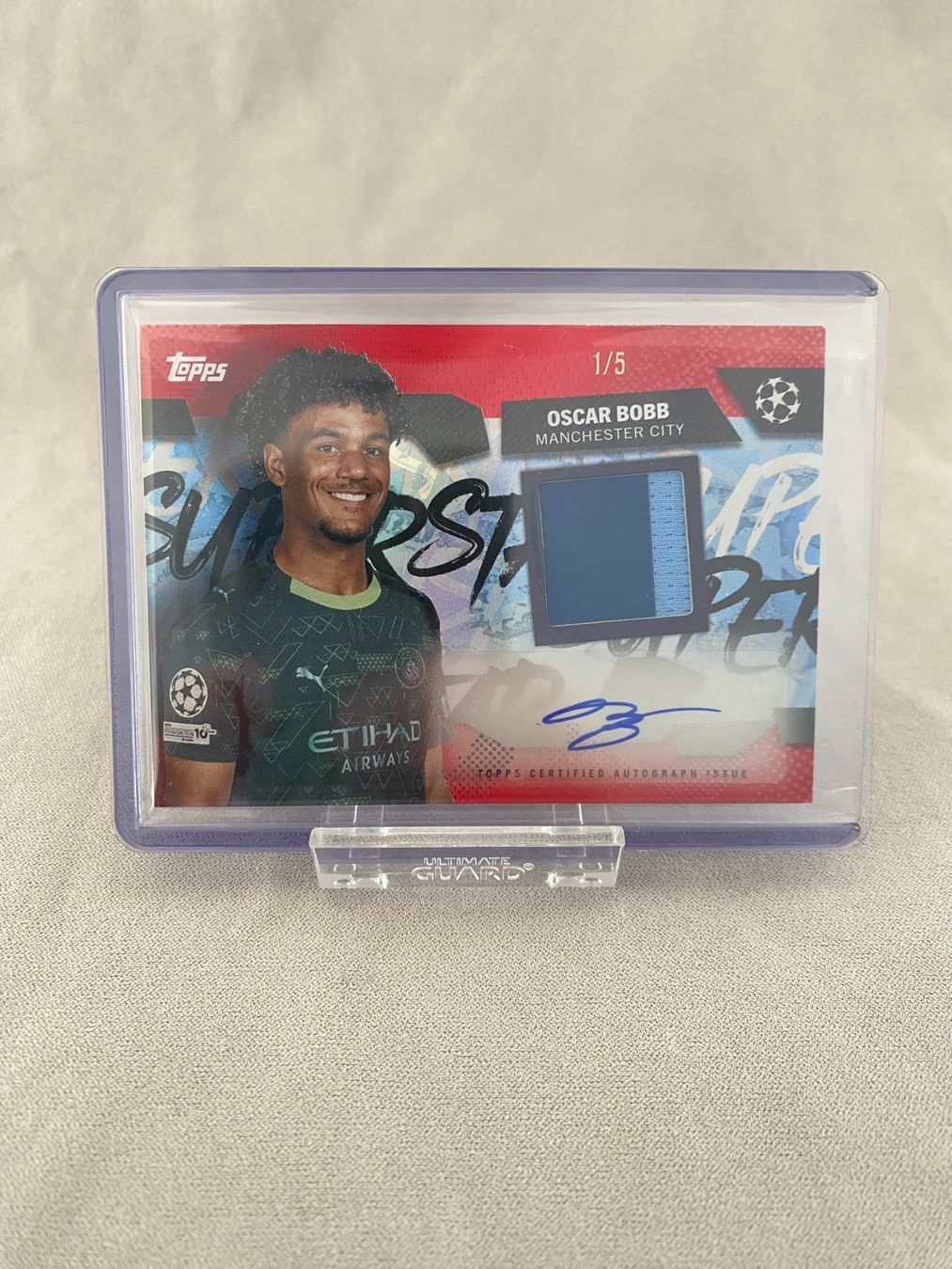 Topps UCC Flagship 2025-26 Oscar Bobb Relic Patch Auto Red/5 (Neu ...