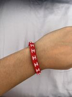 Rotes Armband mit weißen Logos, Durchmesser 6 cm, ungetragen