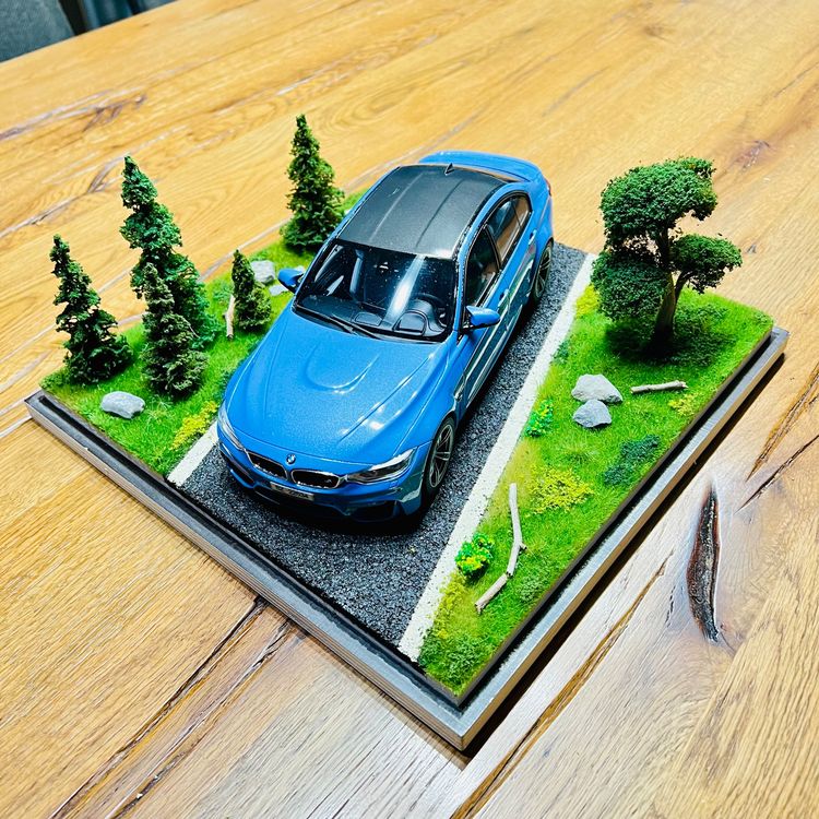 Handcrafted 1:18 scale car displayed in a miniature roadside diorama
