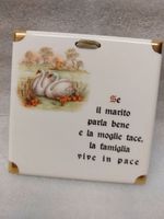 Piastrella decorativa con cigni e scritta satirica