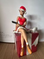 Figurine Lara Croft Noël sur un cadeau, avec pistolet