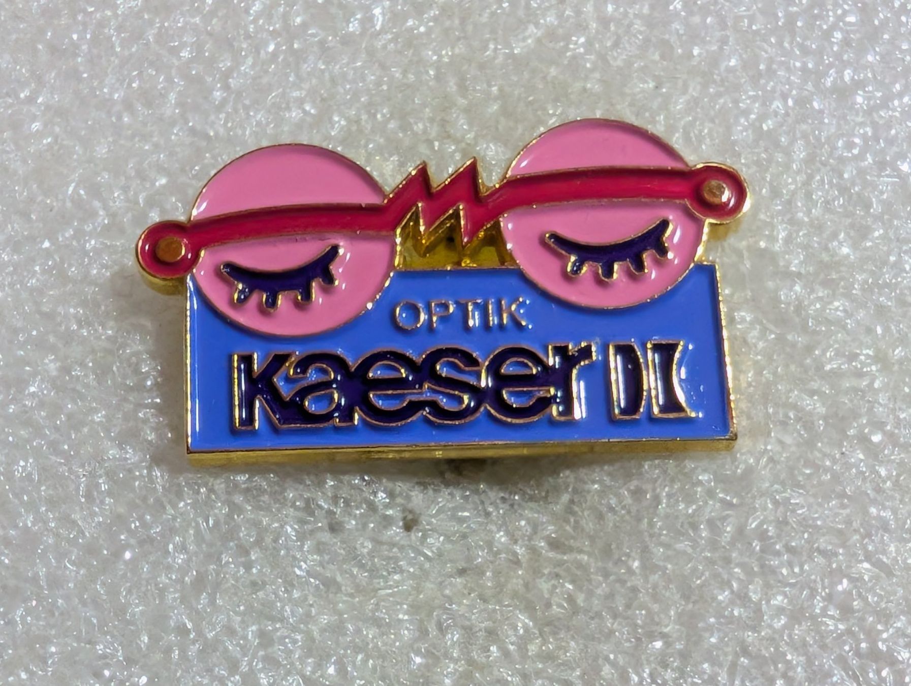 Placchette & Badge: Ansteckpin 196: Optik Kaeserli – Usato da Oppligen venduto da Pin-Fall-Shop