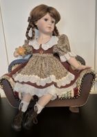 Elegante Porzellanpuppe im Herbstkleid mit Sofa