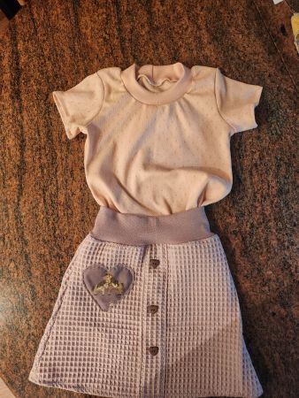 lila Waffeltuchröckli mit rosa T-Shirt Gr. 98