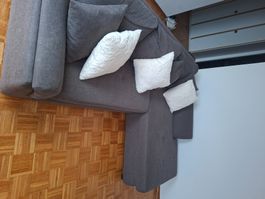 Canapé d'angle gris foncé avec coffre de rangement