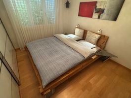 Spezielles Bett aus Holzbalken und Granitfüssen
