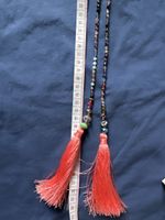 Long collier bohème chic à pompons corail - Été 2024