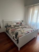 Bett mit Matratze und einem Nachttisch 
