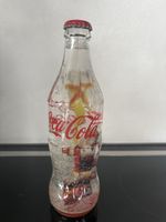 Glass bottle from Coca-Cola with Santa Claus and snowflakes