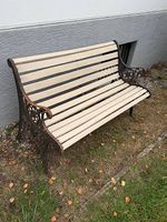 Stilvolle Gartenbank mit verziertem Metallgestell