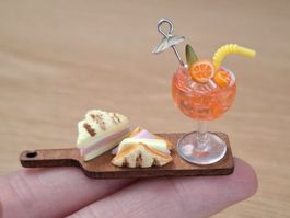 Aperol Spritz mit Cocktailschirmchen und  Sandwich