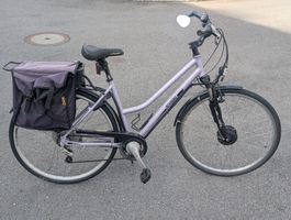 E-Bike Interbike Damenvelo violett mit Gepäcktasche