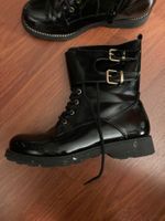 Glänzende schwarze Stiefel mit zwei seitlichen Schnallen