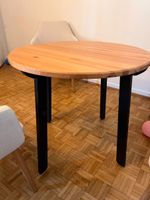runder Ikea-Holztisch mit schwarzen Beinen