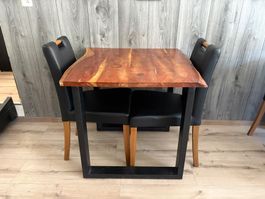 Table en bois massif avec deux chaises noires bon état