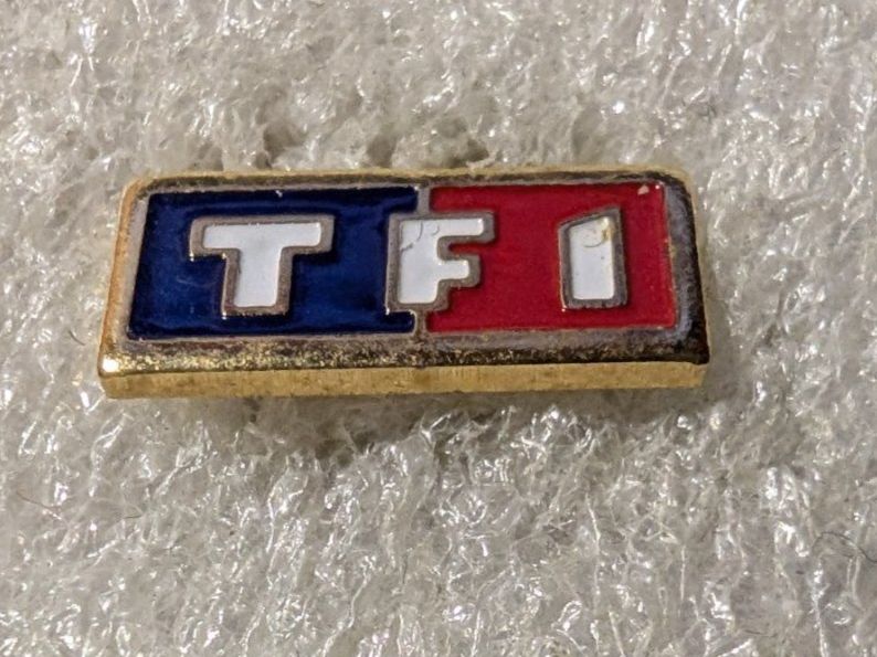 Placchette & Badge: Ansteckpin 207: TF1 – Usato da Oppligen venduto da Pin-Fall-Shop