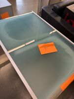 Moderner Glastisch mit Metallrahmen