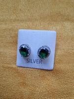 Boucles d'oreilles argentées avec pierres vertes neuves.