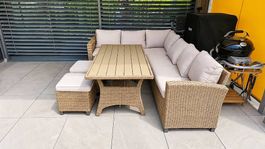 Gepflegte Gartenlounge in Rattan-Optik mit Esstisch