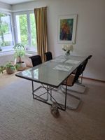Esstisch mit Glasplatte und Metallgestell (ohne Stühle)