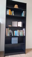 Schwarzes Regal mit Büchern und Deko – *2