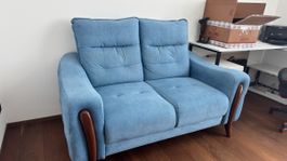 Cosy light blue two-seater sofa, perfect for winter nights