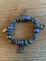Joli bracelet argenté et violet avec breloques