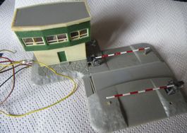 Spur N Bahnübergang mit Schranken und Stellwerk.