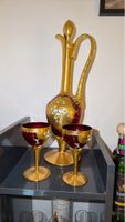 Karaffe und 2 mit Gold verzierte Weingläser aus bordeauxrote