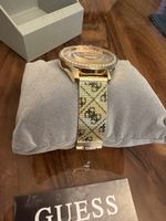 Goldfarbene Guess Analog Damenuhr W1279L2 mit G-Logo-Muster.