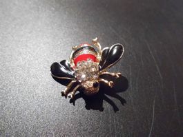 Brosche Fliege, schwarz/goldig/rot