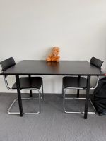 ein Kindertisch und zwei Kinderstühle.