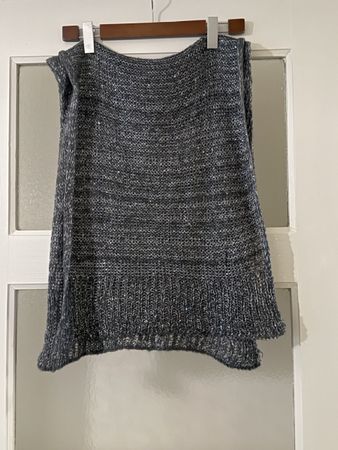 Warmer, grauer Strickschal mit Pailletten-Akzenten.