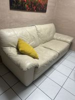 Divano a due posti in pelle color crema usato in buono stato