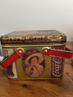 Boîte métallique Coca-Cola style vintage avec poignées.