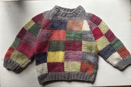 Handgestrickter Kinderpullover aus pflanzengefärbter Wolle