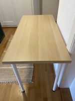 Schreibtisch mit Holzoptik und weissen Beinen