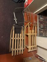 Zwei Holzschlitten mit Kindersitz gebrauchter Zustand