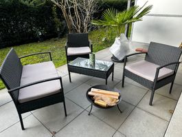 Rattanlounge Garten mit Kissen und Tisch
