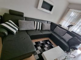Echtleder Sofa mit Deko-Kissen. Schwarzes Ecksofa mit Gebrau