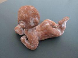 kleine Plastik / Tonfigur: liegendes Baby