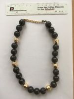 Halskette mit goldfarbigen und schwarzen Kugeln