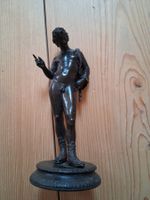 Bronzefarbige Figur auf Sockel